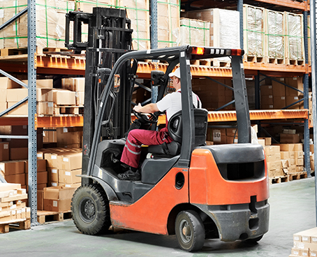 Operator using a Toyota forklift without an air filter to store a last-minute order inside the warehouse.